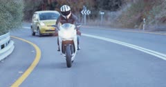 Man riding a sports motorbike at high speed on a curved countryside road