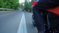 Man riding a sports motorcycle on a curved road
