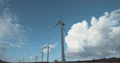 Renewable energy - wind turbines spinning with clouds in the background