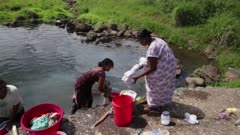 Woman cleaning clothes in water