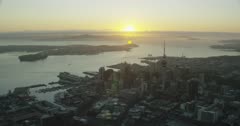Auckland's CBD & Sky Tower at sunrise; looking out towards Rangitoto Island and the Hauraki Gulf, New Zealand