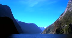 Wide shot of  the Tasman Sea inlet at Milford Sound with a tourist boat in the distance