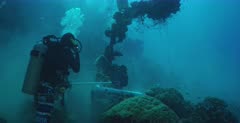Divers retrieving oil off the Shinkoku shipwreck.