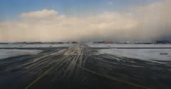 A view from the aircraft passenger window of a plane taxing to take off, at Istanbul Airport that is covered in snowed .