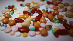 dolly shot of a variety of colorful pills, tablets and capsules
