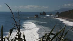 surf rolls in at nine mile, near greymouth, on the west coast of new zealand's south island