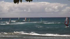 wide shot of a number of windsurfers at ho'okipa, maui