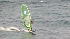long shot of a windsurfer performing a jibe turn at ho'okipa on maui