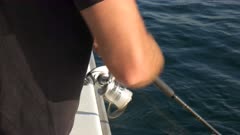 a fisherman uses a spinning reel to catch fish on a charter fishing trip