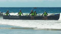 female surf life savers compete in a surf boat race on the sunshine coast of australia