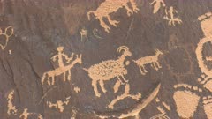 close up of a carving of a human figure on horseback hunting sheep on newspaper rock at canyonlands national park in utah, usa