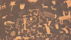 panning shot of an american indian art petroglyph of a hunting scene on newspaper rock at canyonlands national park, utah