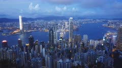 a dusk panning shot of victoria harbour and hong kong island from the peak in hong kong, china