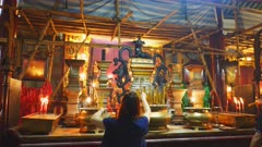 two chinese worshipers lighting incense at man mo temple in hong kong, china