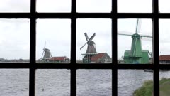 windmills as seen through a window at zaanse schans near amsterdam, netherlands