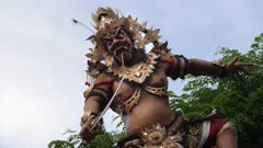 a slow motion shot of an ogoh-ogoh statue with spinning amour at kuta, bali during the hindu new year parade