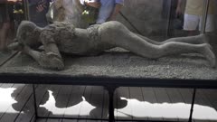 plaster cast of a female victim, in a glass case, at pompeii ruins near naples, italy