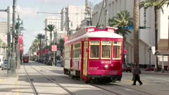 a pedestrian crosses the tracks after a trolley car passes on canal street in new orleans of louisiana, usa