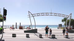 a slow motion tracking shot of the surfers paradise sign and a group of female cyclists on the gold coast of queensland, australia