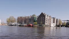 a view of buildings along oudeschans canal as seen from a cruise in amsterdam, netherlands