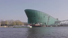 a close view of the nemo building from a canal cruise boat in amsterdam, netherlands