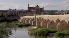 a high angle afternoon view of the ancient roman bridge and the mosque-cathedral of cordoba,spain