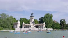 a spring afternoon view of the boating lake and alfonso XII monument in el retiro park at madrid, spain
