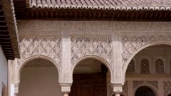 a panning clip of an ornately decorated wall with arabic script at the ancient palace-fortress alhambra of grenada, spain