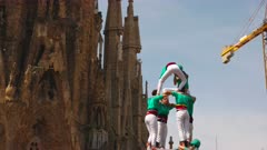 a close view of the castellers de vilafranca team completing a human tower near sagrada familia in barcelona, spain