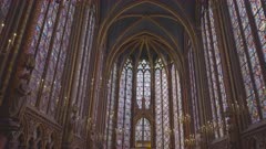 a tilt up clip of the stained glass windows and ceiling of the upper chapel of sainte-chapelle in paris, france