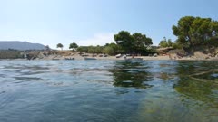 Posidonia seagrass underwater and beach with small boats on Mediterranean coast, Spain, Costa Brava, Portlligat, Cadaques, Cap de Creus, Catalonia