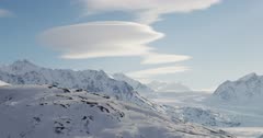 Snow covered mountains near the Knik Glacier, with lenticular clouds 