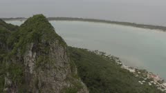 Maupiti Aerial peak and coastline and lagoon enters the frame
