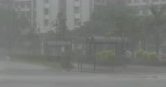 Tropical Storm Rain Lashes Man With Umbrella On City Street