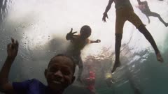 Indonesian Children jumping into the water from a dock