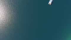 Lone sailboat on the sea surface. Aerial top view 4k