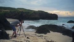A Photographer In Shorts Capturing The Beauty Of Indian Ocean In Watamu Beach In Mombasa, Kenya. -wide shot