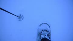 A Man Wearing Snow Shoes, Holding A Ski Pole Slowly Walks Into A Thick Ice In Finland - Close Up Shot