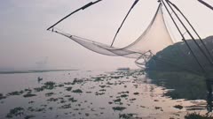 Traditional Chinese fishing nets at sunrise, Fort Kochi, India. Low aerial drone
