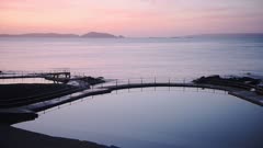 Seascape view of outdoor swimming pools, in the coastline of Guernsey, at dusk