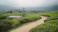 A Small Building In The Middle Of The Hills With A Steep Dirt Road Located In Munnar. -wide shot