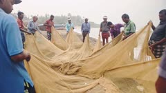 Local people working with traditional fishing nets, Kappil Beach, Varkala, India
