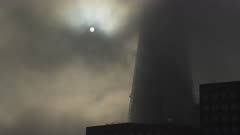 The Shard in London with dramatic moody clouds and mist moving and the sun rising on a misty foggy morning in London, shot in the Covid-19 Coronavirus lockdown in England, Europe