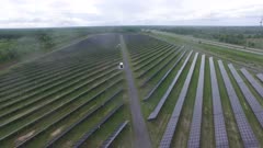 Light raindrops falling into drone's lense while in flight over solar panels