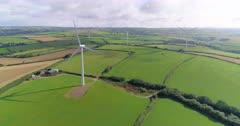 Static aerial shot of large wind farm with multiple wind turbines in the UK