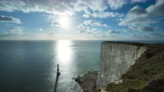 Timelapse from the top of Beachy Head Cliff looking towards lighthouse and sun over sea 8K