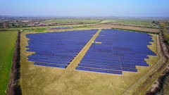 Aerial drone shot ascending to reveal large solar farm in UK 