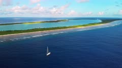 Aerial shot of remote Nikumaroro atoll and sailing boat