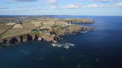 Aerial shot reversing and ascending away from the Cliffs and rocky coastline of Lizard Point in Cornwall UK