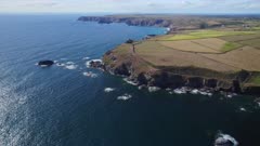 Aerial shot tilting up from ocean to the Cliffs and rocky coastline of Lizard Point in Cornwall UK
